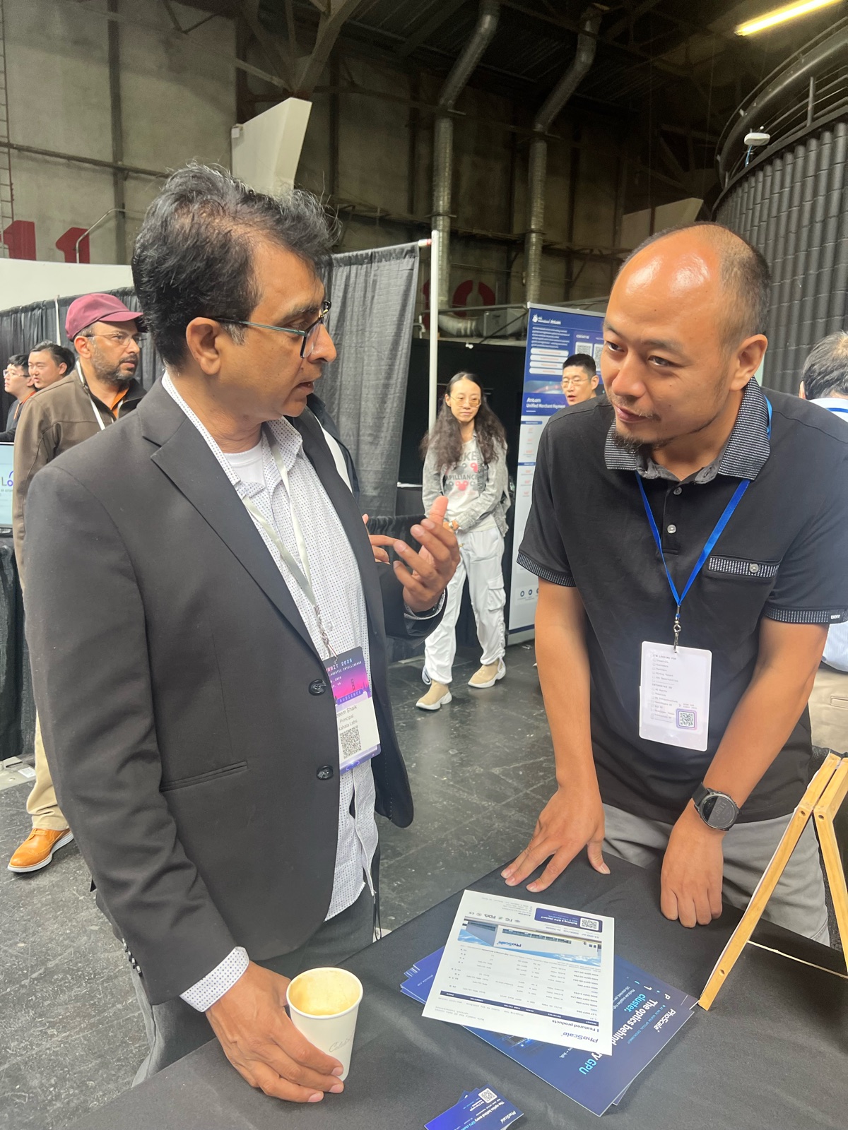PhoScale team member discussing optical transceivers with a visitor at the AGI Summit 2026 booth