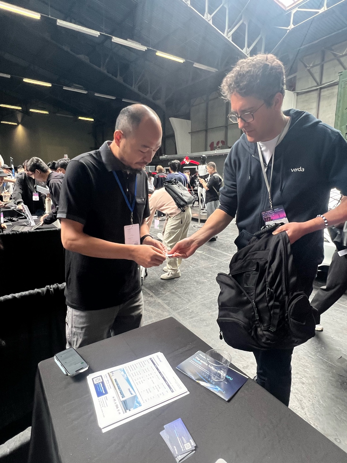 PhoScale handing out product information and sample details to a visitor at the AGI Summit 2026 booth